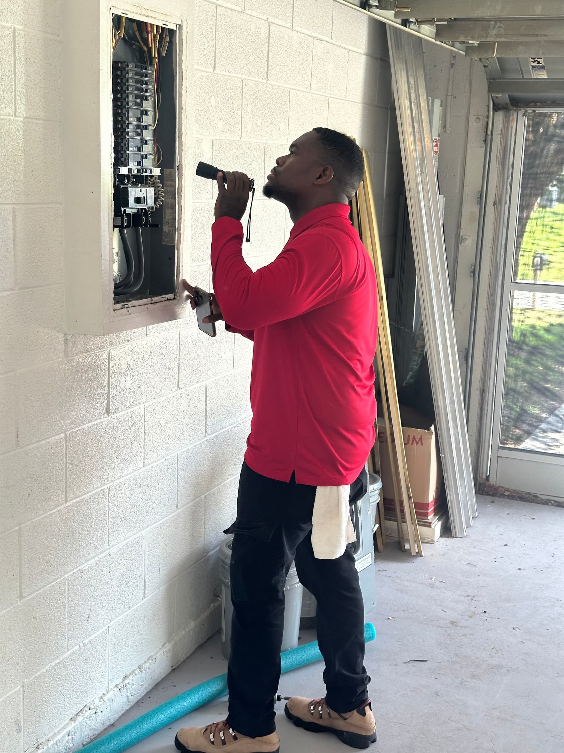 Prolific Home Inspections founder inspecting an electrical panel on site
